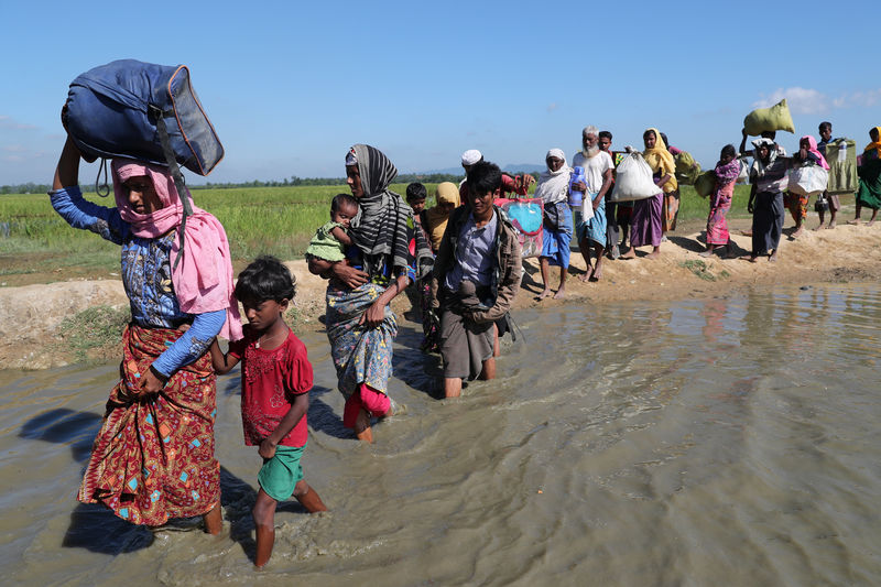 © Reuters. Rohingya refugees walk towards a refugee camp after crossing the border in Anjuman Para near Cox's Bazar