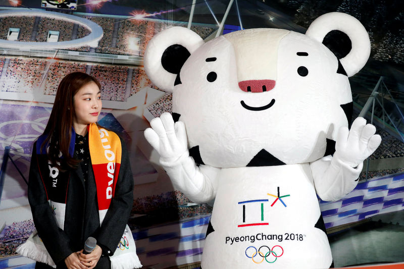 © Reuters. FILE PHOTO: Kim Yuna looks at the Olympic mascot "Soohorang" during the ceremony to mark a year to the 2018 PyeongChang Winter Olympic Games in Gangneung