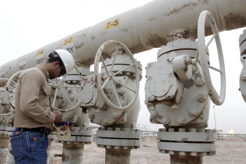 © Reuters. A worker checks the valves at the West Qurna oilfield in southern Basra