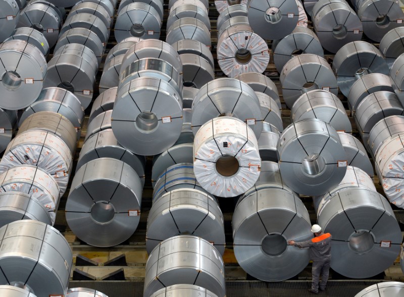 © Reuters. FILE PHOTO: An employee inspects rolls of steel at the plant of German steel company Salzgitter AG in Salzgitter