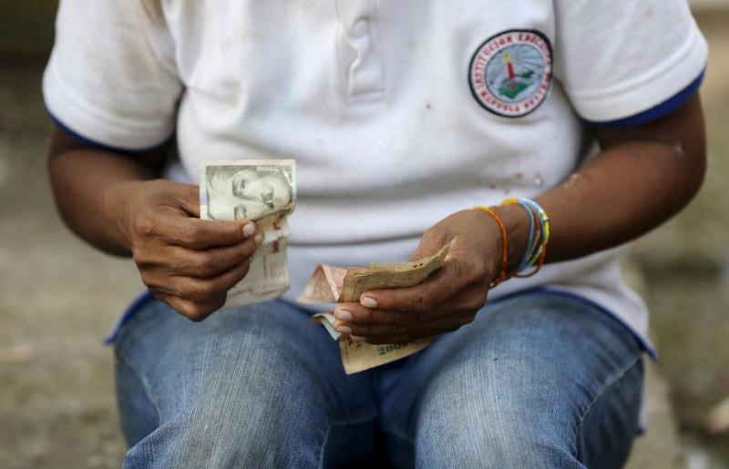 © Reuters. Colombian Nukak Maku Indian woman counts money at a park in San Jose del Guaviare