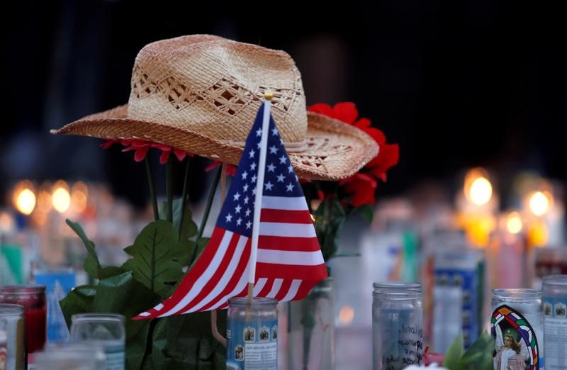 © Reuters. A hat rests on flowers in a makeshift memorial during a vigil marking the one-week anniversary of the October 1 mass shooting in Las Vegas