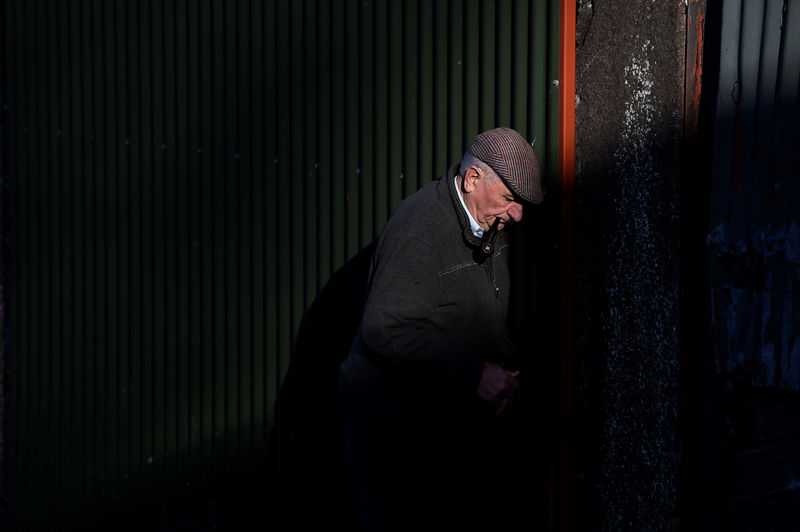 © Reuters. Farmer Frank Maguire and father of farmer Philip Maguire is seen closing the cattle shed on their farm in Stepaside