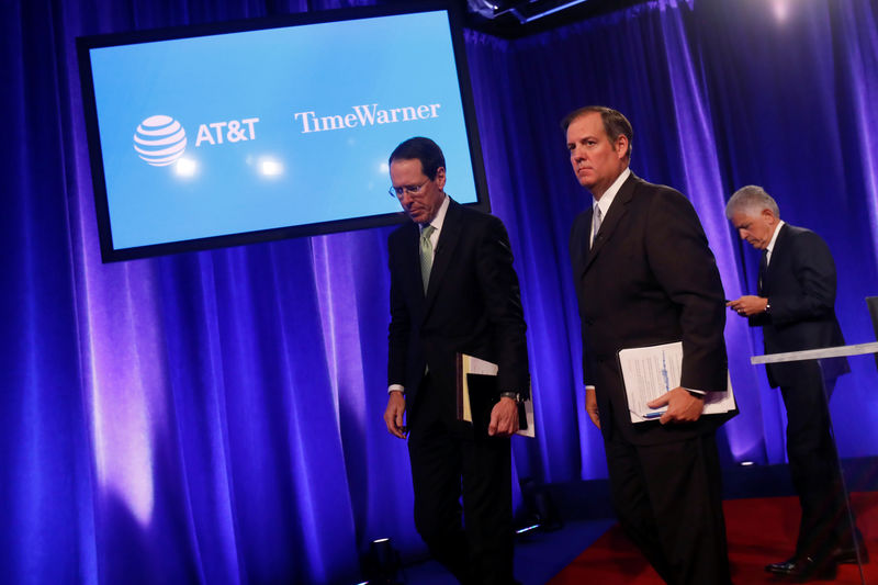 © Reuters. Chief Executive Officer of AT&T Randall Stephenson walks off the stage with David McAtee, SEVP and General Counsel for AT&T, and Daniel Petrocelli, counsel from O'Melveny & Myers LLP., after a press conference in New York City