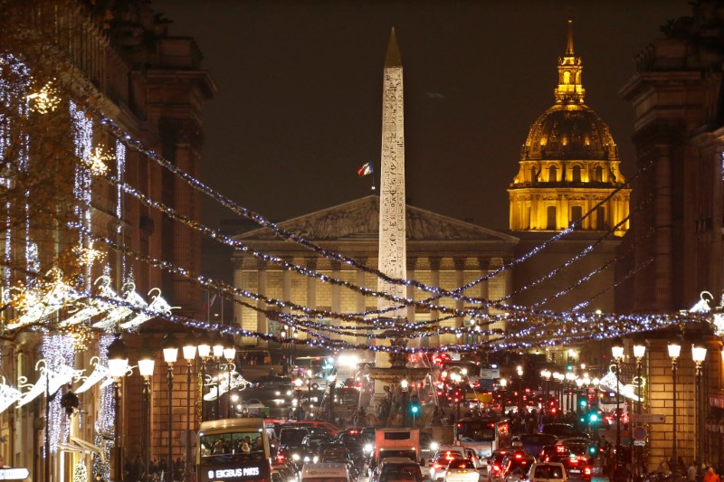 © Reuters. Christmas holiday lights hang from trees to illuminate the rue Royale in front of the Place de la Concorde, the Luxor Obelisk and the Dome des Invalides as part of illuminations for the Christmas holiday season in Paris