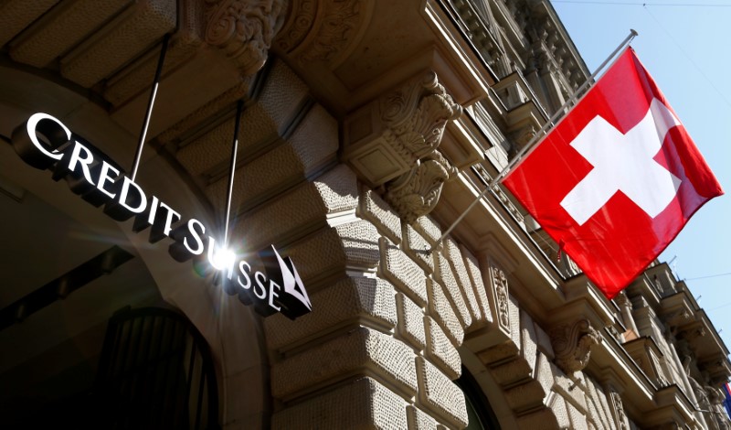 © Reuters. Switzerland's national flag flies beside the logo of Swiss bank Credit Suisse in Zurich