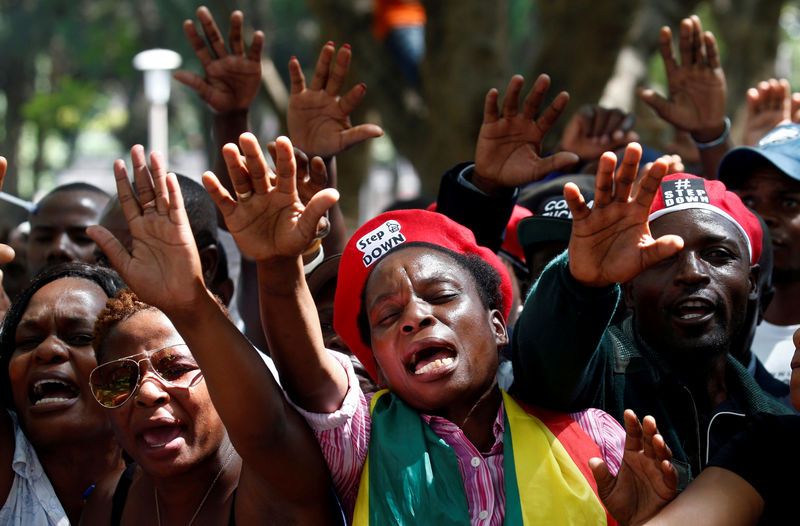 © Reuters. Протестующие призывают президента Зимбабве Роберта Мугабе уйти в отставку