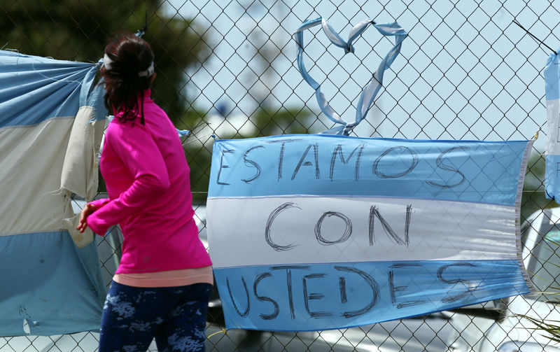 © Reuters. Mulher caminha diante de bandeira argentina em base naval em Mar del Plata