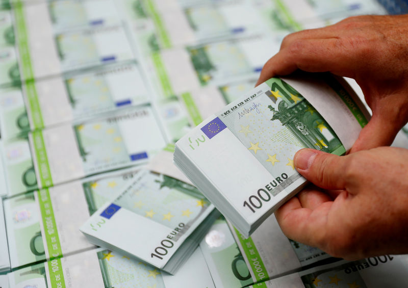 © Reuters. FILE PHOTO: An employee checks 100 Euro banknotes at the Money Service Austria company's headquarters in Vienna