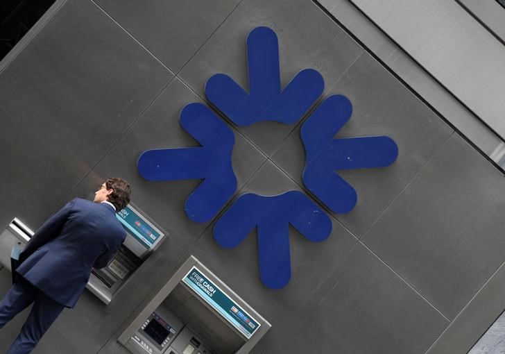 © Reuters. A customer uses an ATM at a branch of RBS bank in the City of London financial district in London