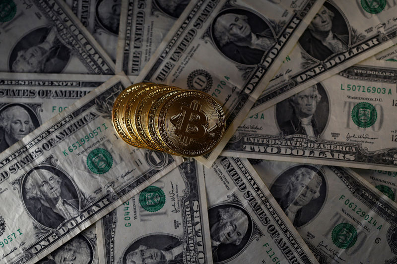 © Reuters. Bitcoin (virtual currency) coins placed on Dollar banknotes are seen in this illustration picture