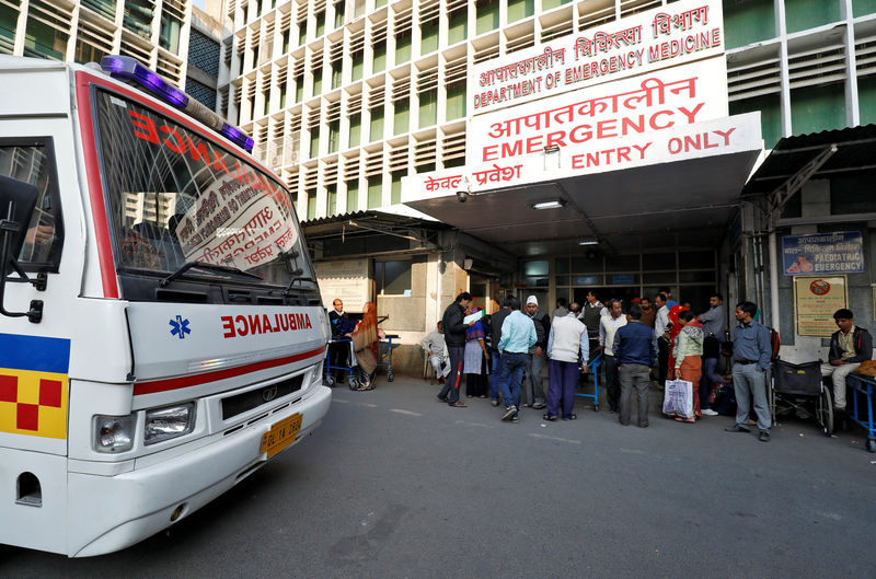 © Reuters. An ambulance arrives as people stand at the entrance of the emergency department of a government-run hospital in New Delhi