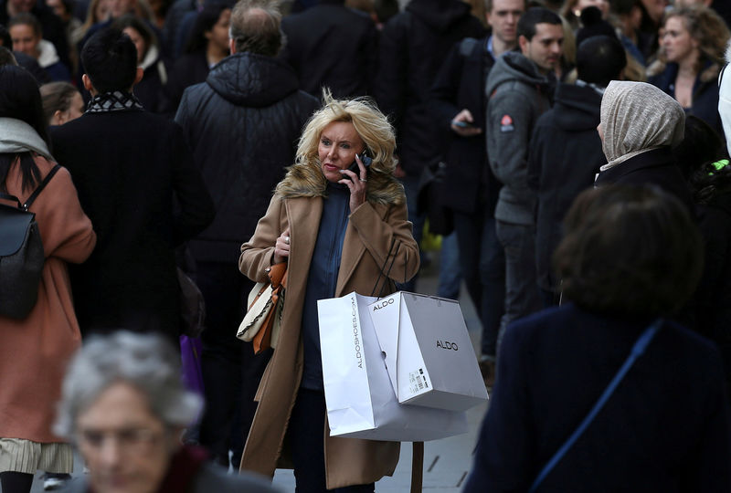 © Reuters. FILE PHOTO: A shopper speaks on her mobile phone as she walks along Oxford Street in London