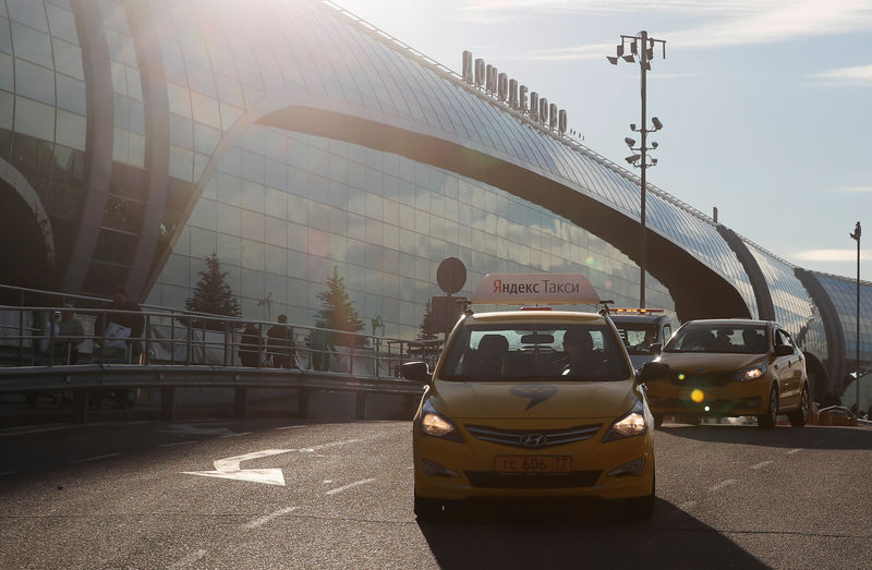 © Reuters. FILE PHOTO: A taxi with the logo of Russian online taxi service Yandex Taxi drives past a terminal of the Domodedovo Airport outside Moscow