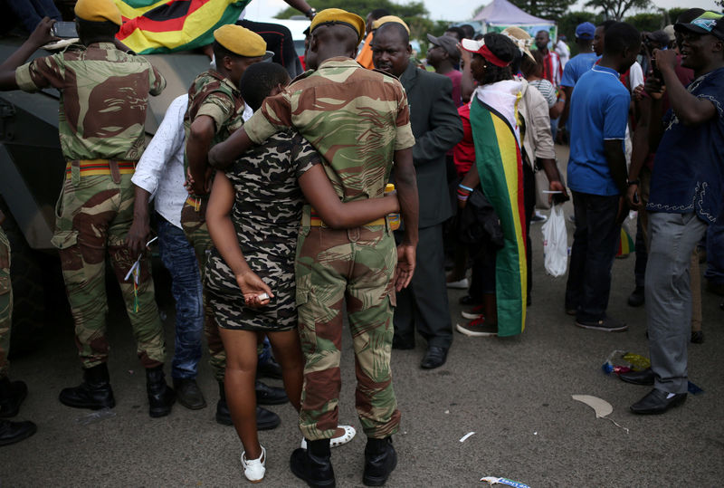 © Reuters. A member of Zimbabwe military chats with a local after the swearing in of Emmerson Mnangagwa as Zimbabwe's new president in Harare, Zimbabwe
