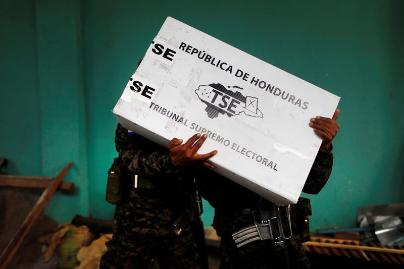 © Reuters. Un grupo de soldados descarga material electoral para su distribución en los colegios antes de los comicios presidenciales en Tegucigalpa, Honduras.