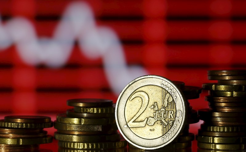 © Reuters. Euro coins are seen in front of a displayed stock graph in this photo illustration taken in Zenica