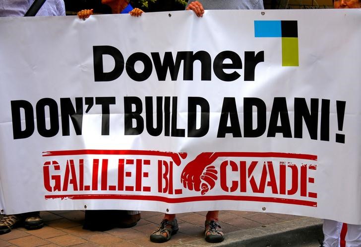 © Reuters. FILE PHOTO: Protesters against the Indian conglomerate Adani Enterprises hold a banner outside the venue for the Australian diversified mining contractor Downer EDI Limited's annual general meeting in Sydney