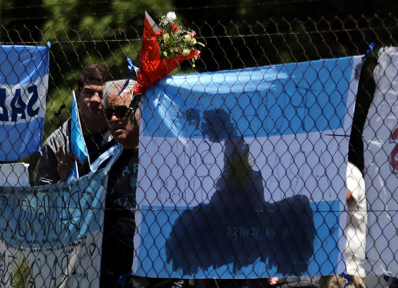 © Reuters. Flores e bandeiras são colocadas em cerca na base naval argentina em Mar del Plata