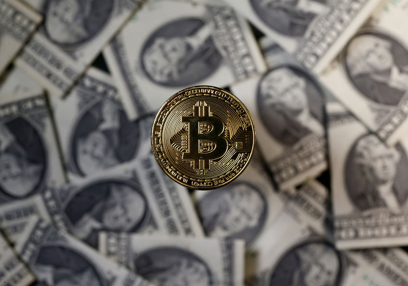 © Reuters. FILE PHOTO - A bitcoin (virtual currency) coin placed on Dollar banknotes is seen in this illustration picture