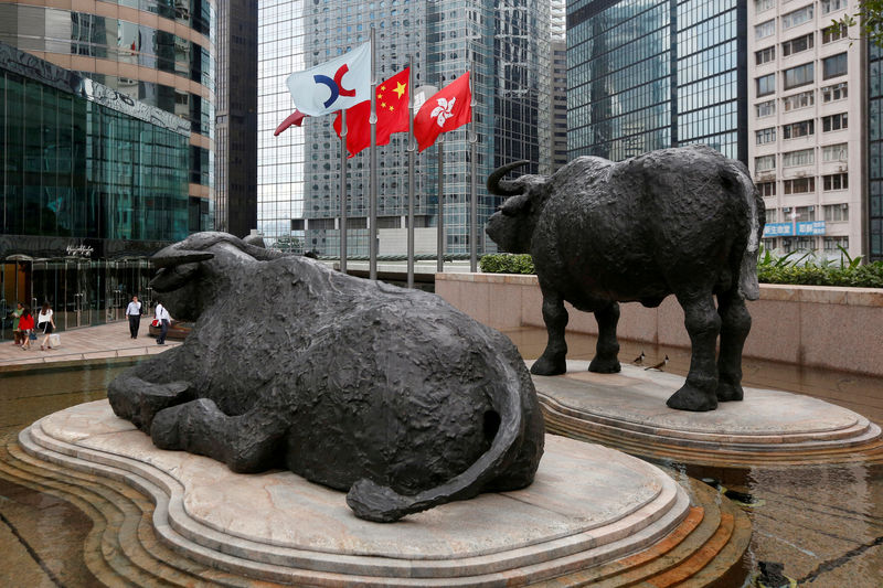 © Reuters. FILE PHOTO: Hong Kong Exchanges flag, Chinese national flag and Hong Kong flag are hoisted outside Hong Kong Stocks Exchange