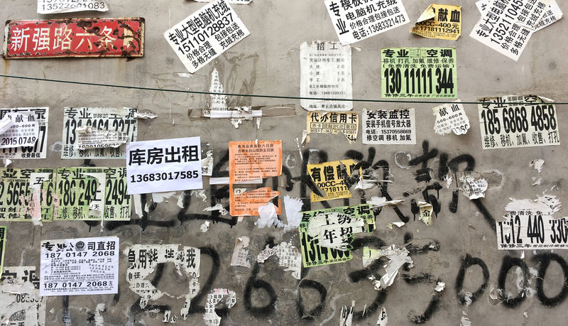 © Reuters. Advertisements are seen posted on a wall in an area where residents are required to move out, due to a citywide fire safety inspection prompted by a deadly fire in an apartment block, at Xinjiancun