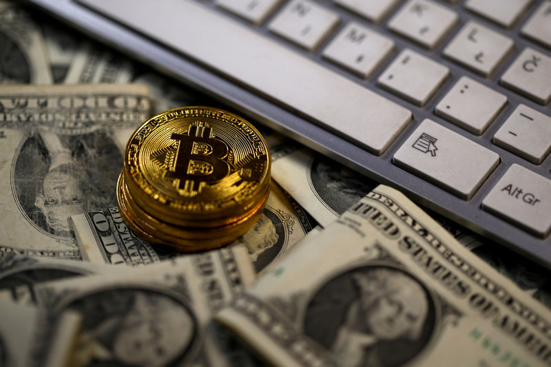 © Reuters. FILE PHOTO: Bitcoin (virtual currency) coins placed on Dollar banknotes are seen in this illustration picture