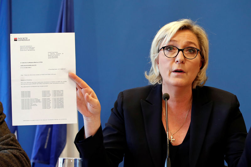 © Reuters. Marine Le Pen, head of France's far-right National Front (FN) political party, shows a letter from the Societe Generale bank during a news conference at the party headquarters in Nanterre near Paris