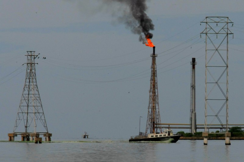 © Reuters. A boat is seen close to oil installations at Lake Maracaibo in Cabimas