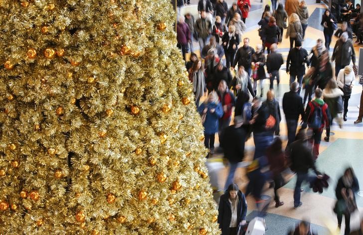 © Reuters. People walk in a shopping mall next a Christmas tree in Berlin