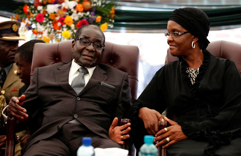 © Reuters. FILE PHOTO - File photo of Zimbabwe President Robert Mugabe speaking to his wife Grace during the funeral of his sister, Bridget in the village of Zvimba