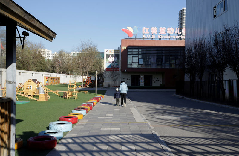 © Reuters. Child walks with a parent at the kindergarten run by pre-school operator RYB Education Inc