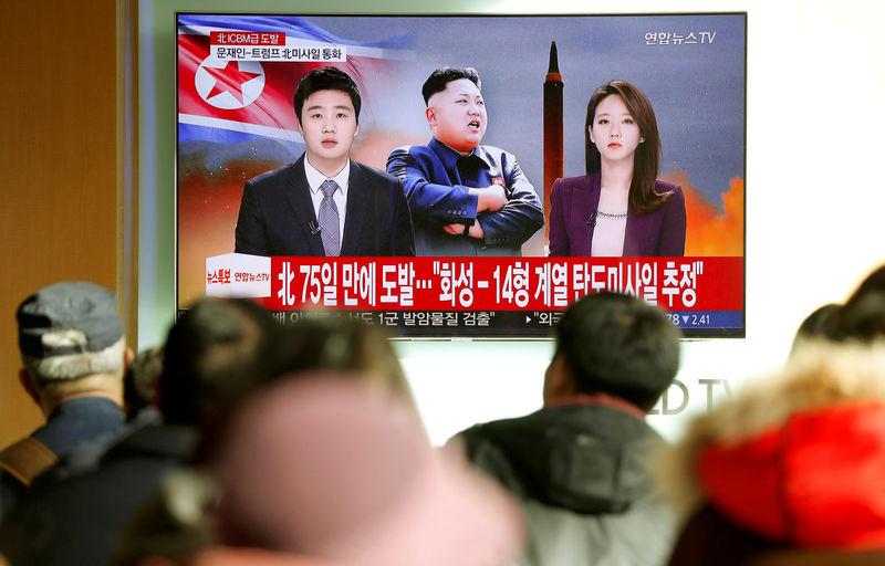 © Reuters. People watch a TV broadcasting a news report on North Korea firing what appeared to be an intercontinental ballistic missile (ICBM) that landed close to Japan, in Seoul