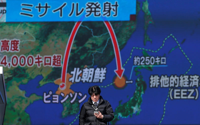 © Reuters. Homem passa por tela que exibe reportagem sobre teste de míssil da Coreia do Norte, em Tóquio, no Japão