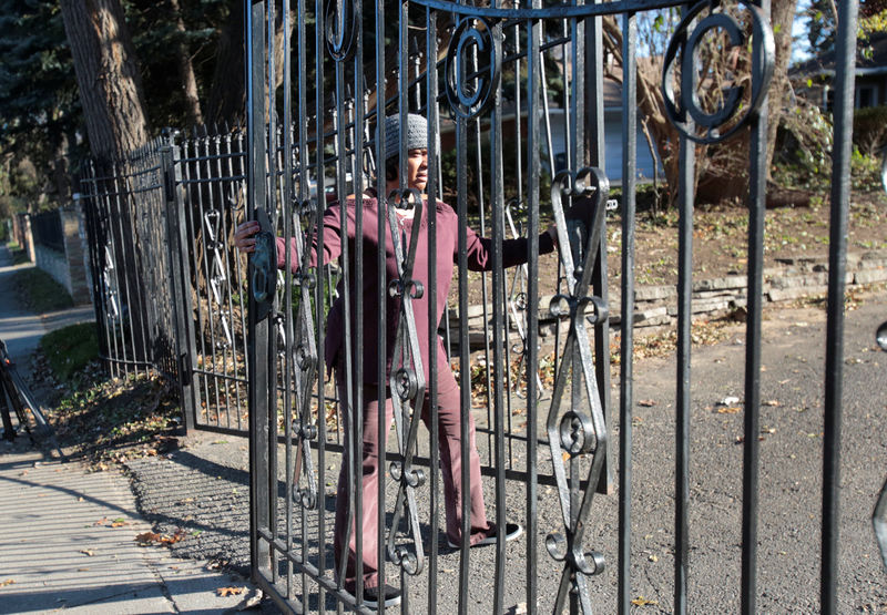 © Reuters. Monica Morgan, wife of U.S. Rep John Conyers, closes the gates in front of the family home in Detroit