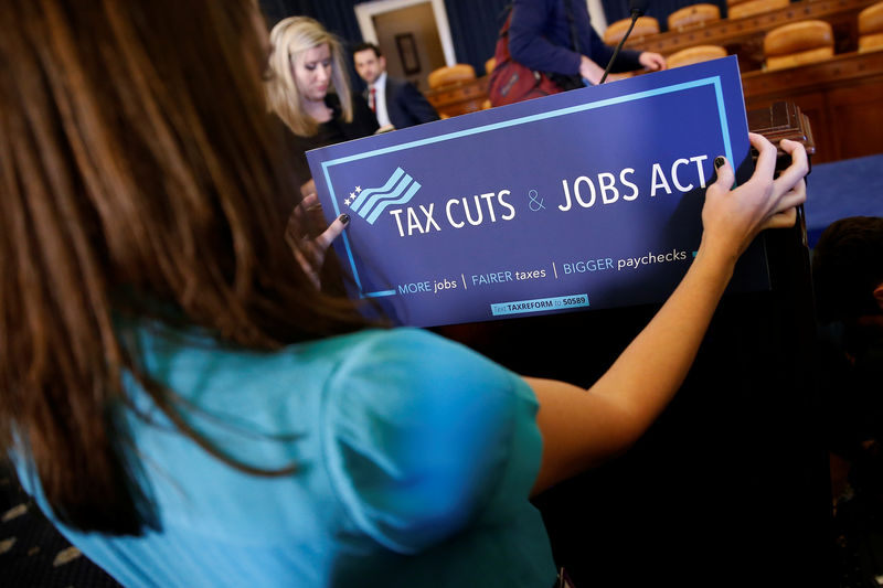 © Reuters. An congressional aide places a placard on a podium for the House Republican's legislation to overhaul the tax code on Capitol Hill in Washington