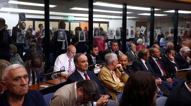 © Reuters. Manifestantes seguram retratos de pessoas desaparecidas durante julgamento de oficiais da Marinha por crimes cometidos na ditadura argentina, em Buenos Aires