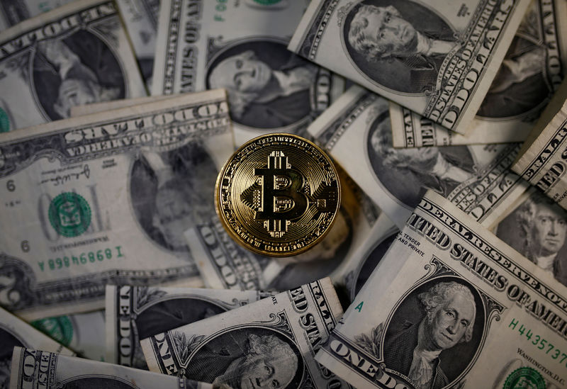 © Reuters. FILE PHOTO - A bitcoin (virtual currency) coin placed on Dollar banknotes is seen in this illustration picture