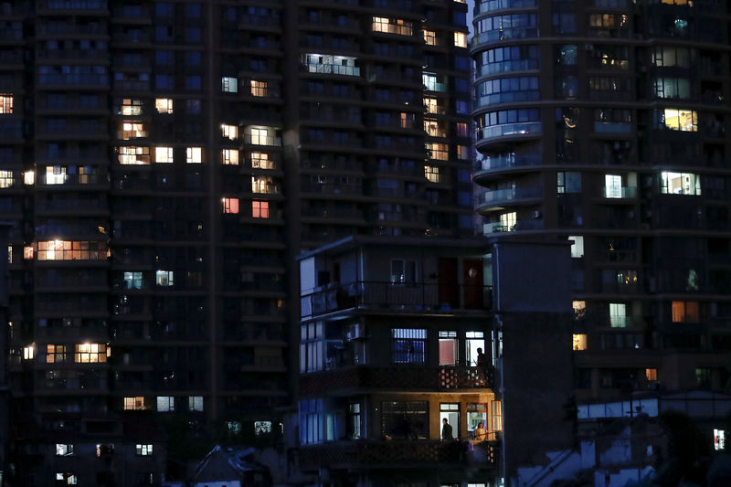 © Reuters. FILE PHOTO: An old house is seen in front of new apartment buildings in Guangfuli neighbourhood, in Shanghai