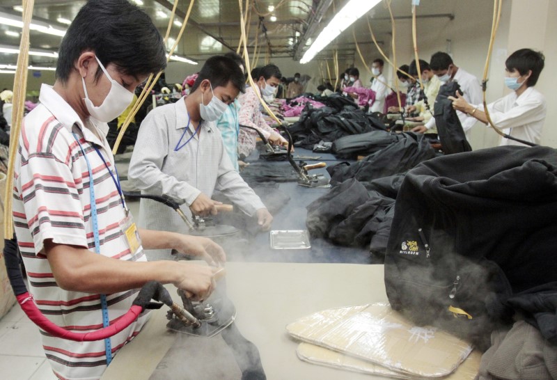© Reuters. FILE PHOTO: Men work in the W & D Cambodia Co. Limited garment factory in Phnom Penh
