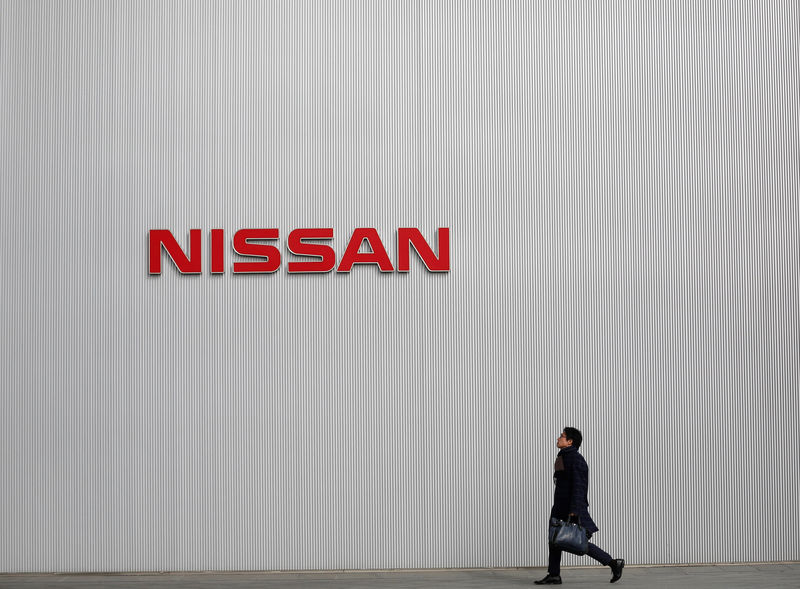 © Reuters. FILE PHOTO: Man walks under the logo of Nissan Motor Co at the company's showroom in Yokohama