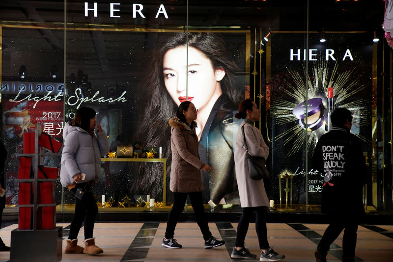 © Reuters. People walk past the window display of a cosmetic at a shopping mall in Shanghai
