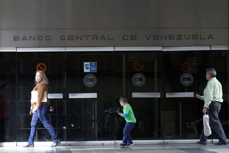 © Reuters. People walk past an entrance of the Venezuela's Central Bank in Caracas