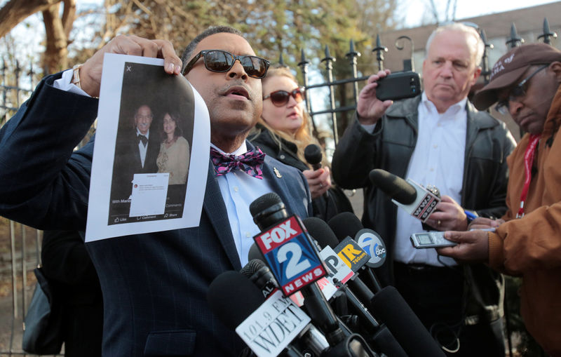 © Reuters. Arnold Reed, attorney for U.S. Rep. John Conyers, holds up an image of Conyers and Marion Brown, one of the two women accusing the congressman of inappropriate behavior, as he addresses the media outside Conyers family home in Detroit