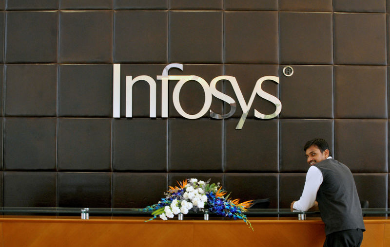 © Reuters. FILE PHOTO: A Infosys employee stands at the front desk of its headquarters in Bengaluru, India