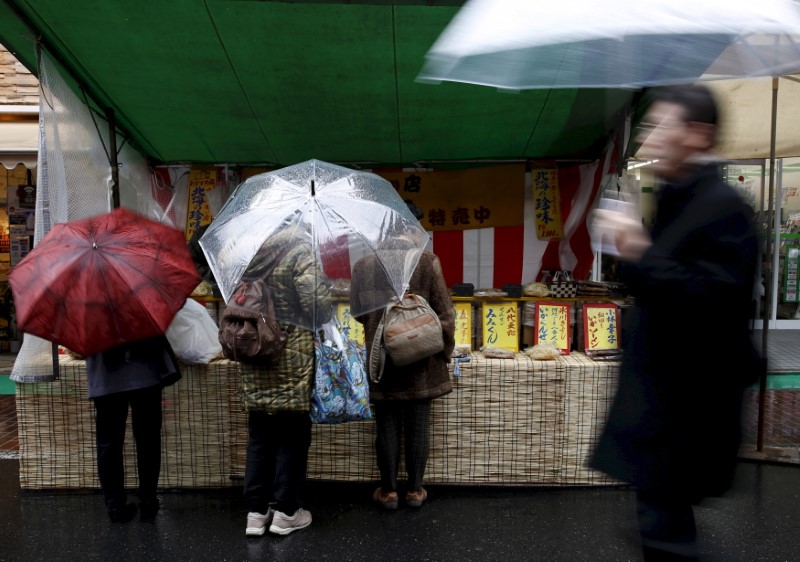 © Reuters. File photo of shoppers sampling dried foodstuff at a stall at Tokyo's Sugamo district