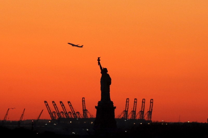 © Reuters. FILE PHOTO: A plane is seen during take off behind the Statue of Liberty in New York's Harbor as seen from the Brooklyn borough of New York