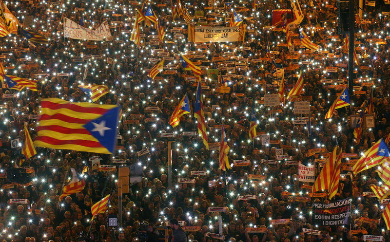 © Reuters. Protesters hold the lights of their mobile phones as they wave Estelada flags during a demonstration called by pro-independence associations asking for the release of jailed Catalan activists and leaders, in Barcelona