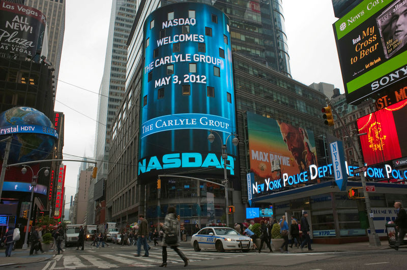 © Reuters. FILE PHOTO: Passersby walk in front of the NASDAQ market site in New York's Times Square