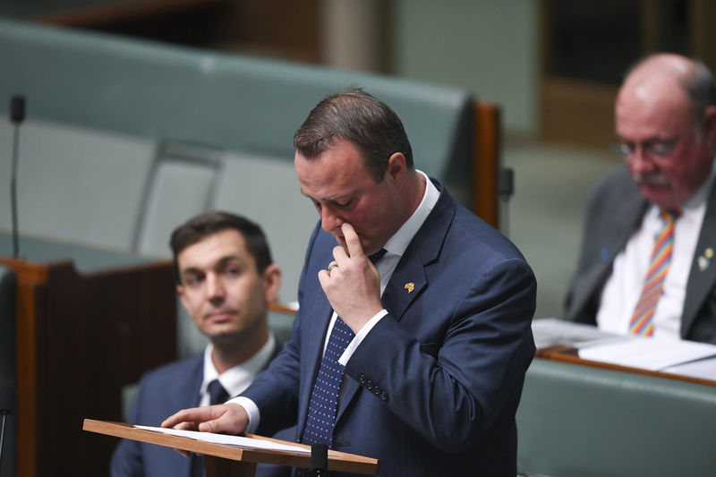 © Reuters. Parlamentar australiano Tim Wilson reage após pedir parceiro Ryan Bolger em casamento na câmara baixa do Parlamento, em Canberra